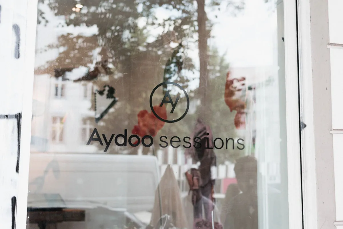 Storefront in Berlin with the Aydoo Sessions logo on glass.