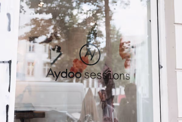 Storefront in Berlin with the Aydoo Sessions logo on glass.